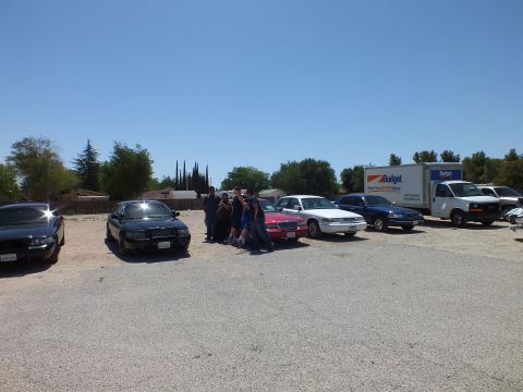 2003 Ford Crown Victoria - Distant view of a sedan meet with vehicles parked in a row and a small group of people.
