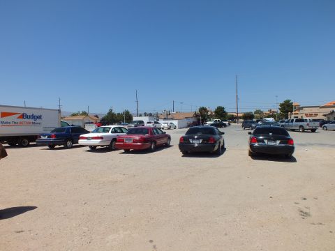 2003 Ford Crown Victoria - Blue, white, maroon and black sedans plus a BMW parked across an open dirt lot