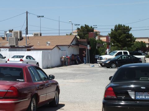 2003 Ford Crown Victoria - Two parked sedans frame a residential building and pickup, a black car shows an EVOLVE plate