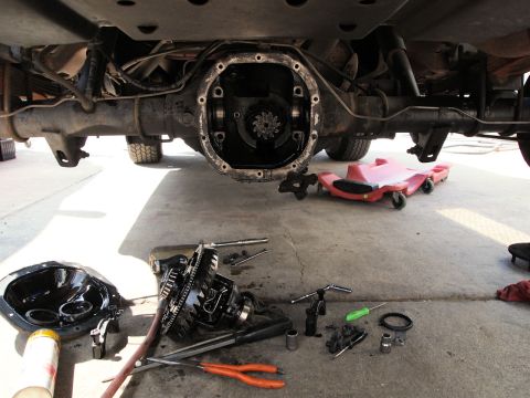 1994 Ford Bronco - Underneath view of a vehicle's rear differential being serviced with tools and parts laid out.