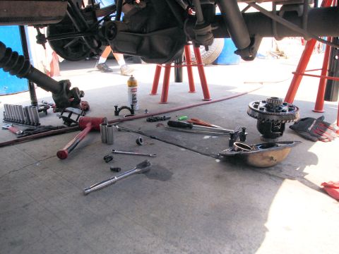 1994 Ford Bronco - Tools are scattered around a vehicle's undercarriage during a differential repair.