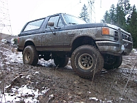 1986 Ford Bronco - This 1986 Ford Bronco is shown off-roading in a muddy, wooded area.