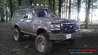 1986 Ford Bronco - This 1987-1991 Ford Bronco is covered in mud and parked in a forest setting.