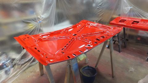 1983 Ford Bronco - Car hoods are being prepped and painted in a spray booth.