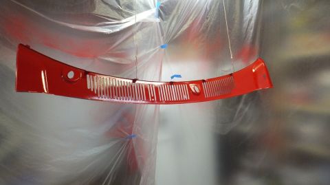 1983 Ford Bronco - A red grille hangs suspended, undergoing a paint job, with a watermark visible.