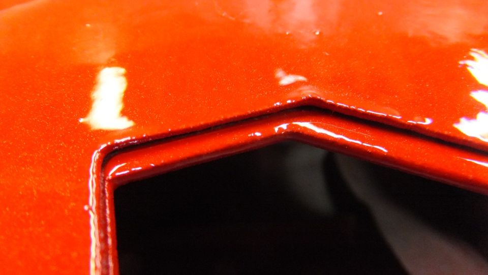 Orange painted metal panel with a recessed area and glossy finish