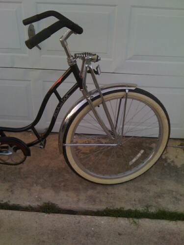 1953 Ford Mainline - This bicycle features a black frame, chrome fenders, and whitewall tires, with a Schwinn logo visible on the frame.