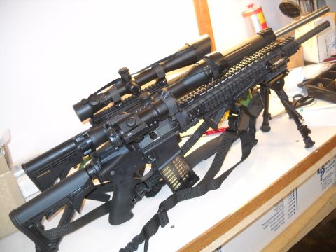 2012 Ford Mustang - Two tactical rifles with scopes and bipods are displayed on a surface.