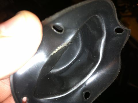 2002 Ford Mustang - A hand holds a black plastic automotive part with visible wear and tear.