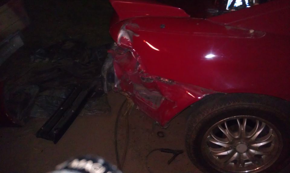Red sports car's rear quarter panel is heavily damaged and dented