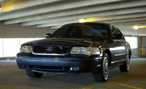 1998 Ford Crown Victoria - A dark 2003 Ford Crown Victoria is parked in a garage with overhead lighting.