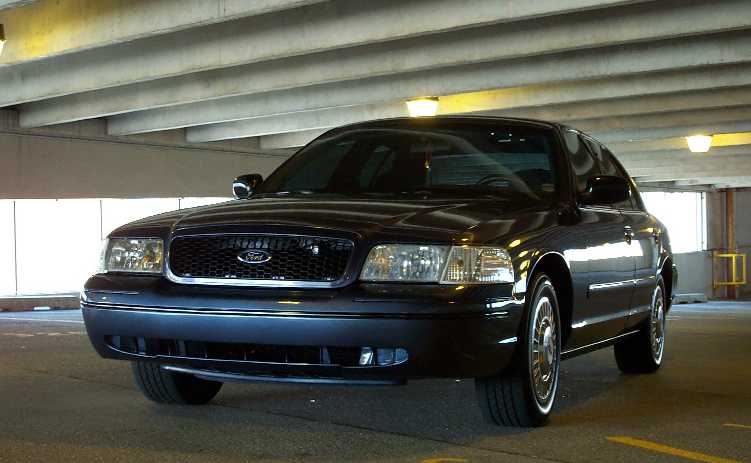 Black Ford sedan, front 3/4 view, parked in concrete garage