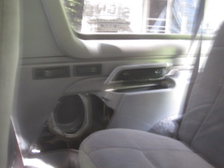 1993 Ford Bronco - Interior view of a 1993 Ford Bronco's door panel, showing a speaker cutout and light grey fabric.