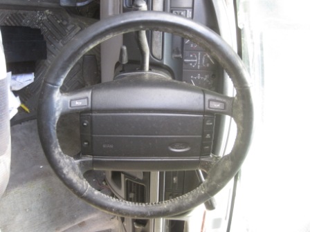 1993 Ford Bronco - The interior of a vehicle is shown, focusing on the steering wheel and dashboard area.