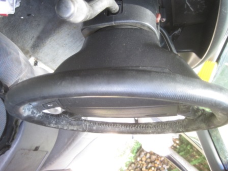 1993 Ford Bronco - Interior view of a worn steering wheel, showing damage to the leather wrap.
