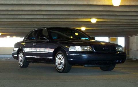 1998 Ford Crown Victoria - A dark blue 1998 Ford Crown Victoria is seen from a three-quarter front view in a parking garage.
