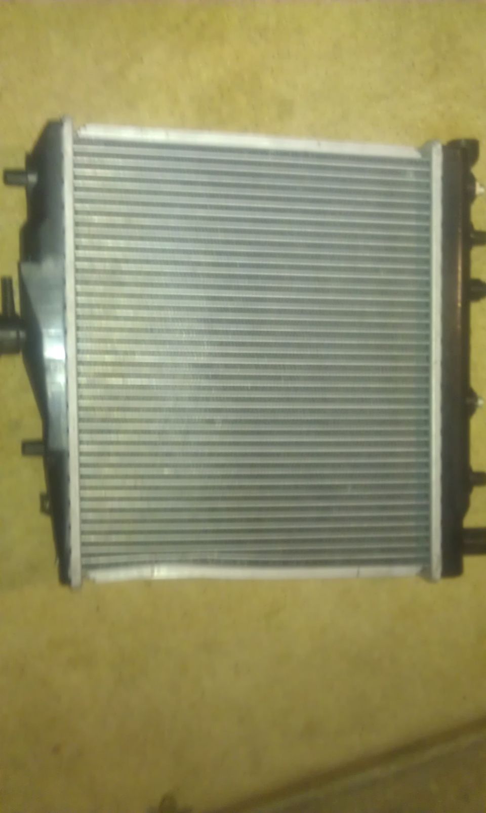 Radiator with black plastic end tanks and a silver finned core