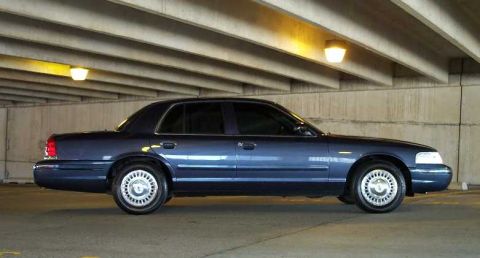 1998 Ford Crown Victoria - Side view of a dark blue 1998 Ford Crown Victoria parked indoors.
