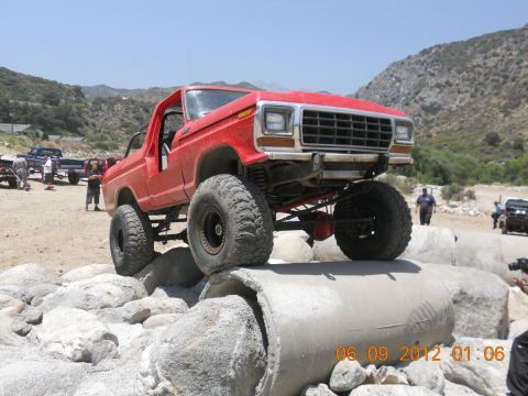 1986 Ford Bronco - This modified SUV is navigating a rocky obstacle course on a sunny day.