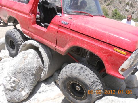 1986 Ford Bronco - This red off-road vehicle is navigating a challenging obstacle course.