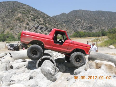 1986 Ford Bronco - This modified Bronco is navigating a rocky obstacle course with other vehicles nearby.