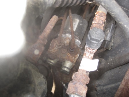 1993 Ford Bronco - Close-up of a rusty ABS control module and associated brake lines, likely from an older vehicle.