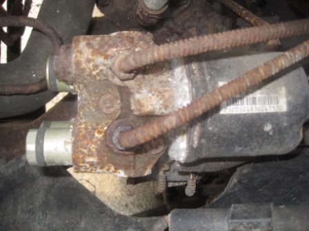 1993 Ford Bronco - A heavily rusted brake component is shown, with a label on the black box containing a barcode and numbers.