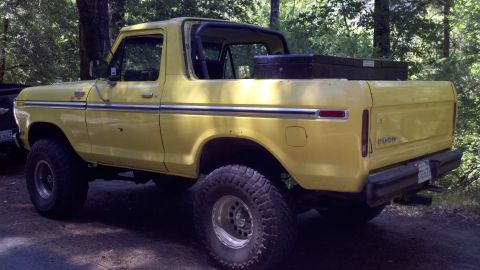 1978 Ford Bronco - This yellow 1978 Ford Bronco is parked outdoors with a toolbox secured in the cargo area.