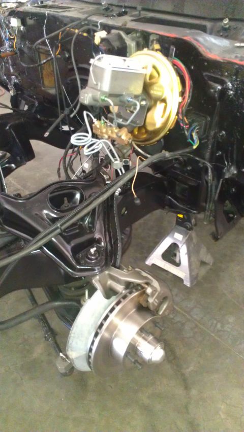 1973 Chevrolet Camaro - Front suspension and engine bay components are visible, with the vehicle supported by jack stands.