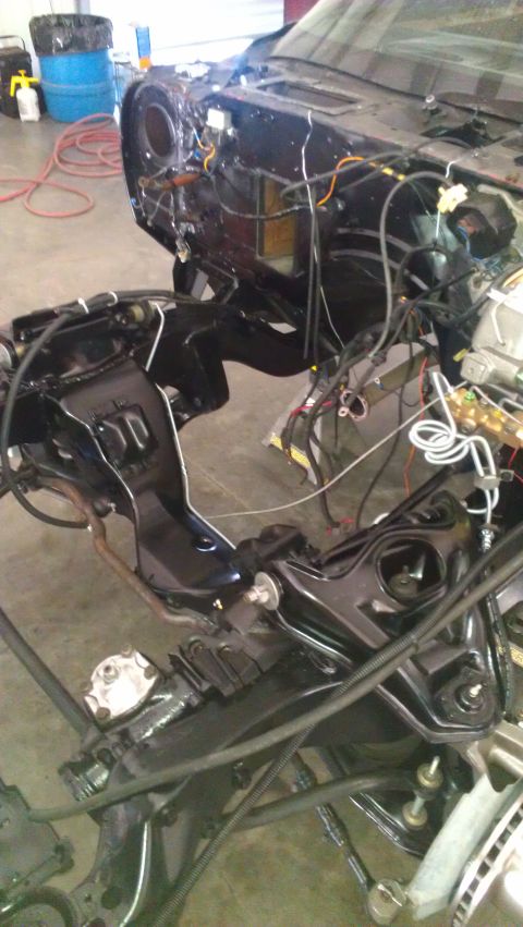 1973 Chevrolet Camaro - The front end of a car is disassembled, revealing the engine bay and chassis structure.