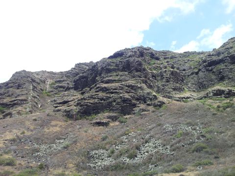 1990 Chevrolet Suburban - A view of a , rocky mountainside with sparse vegetation and a cloudy sky above.