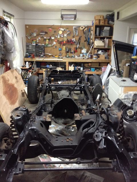 1986 Ford Bronco - The chassis of a vehicle is visible in a workshop, undergoing repairs or restoration.