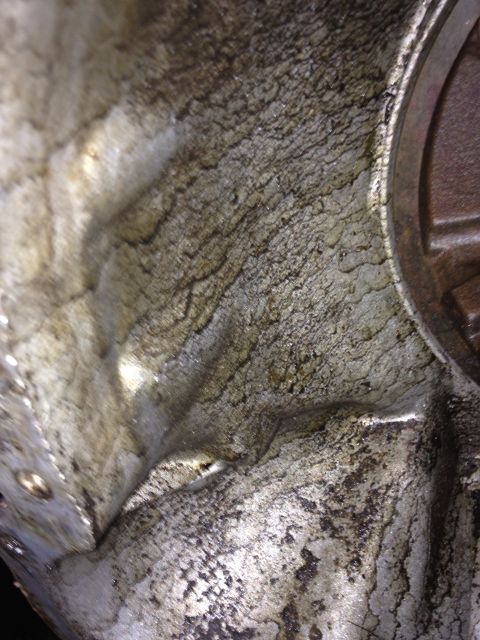 1986 Ford Bronco - The interior of an engine block shows significant wear and grime, with a textured, uneven surface.