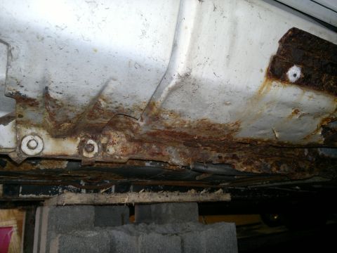 1993 Ford Taurus - The underside of a vehicle displays extensive corrosion and structural degradation.