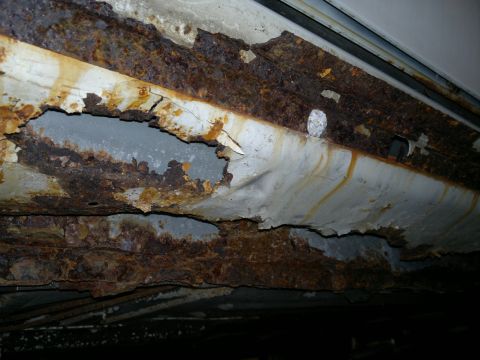 1993 Ford Taurus - Severe rust damage is visible on the undercarriage of a vehicle.