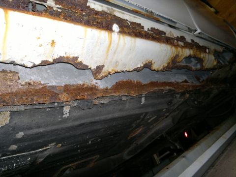 1993 Ford Taurus - Extensive rust damage is visible on the undercarriage of this vehicle, indicating severe structural degradation.