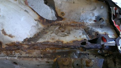 1993 Ford Taurus - Extensive rust damage is visible on the vehicle's frame, indicating significant deterioration.