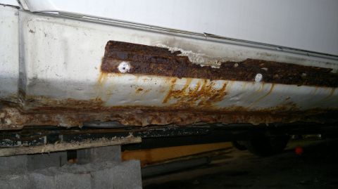 1993 Ford Taurus - Severe rust damage is visible on the rocker panel of this vehicle.