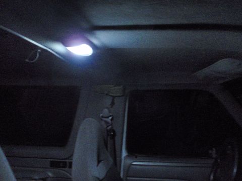 1995 Ford Bronco - The interior of a vehicle is dimly lit by the overhead dome light.
