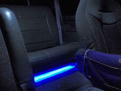 1995 Ford Bronco - The interior of a car is illuminated by blue underglow lighting, with a blue bag visible on the seat.