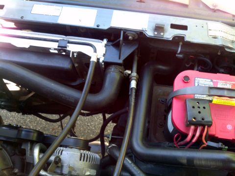 1993 Ford Bronco - Close-up view of engine bay components including hoses, alternator, and battery.