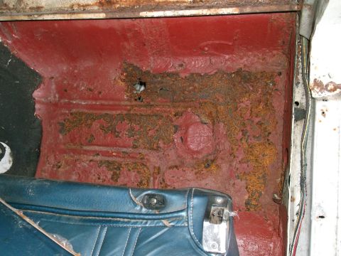 1971 Ford Ranchero - The interior floor pan shows significant rust damage and peeling red paint.