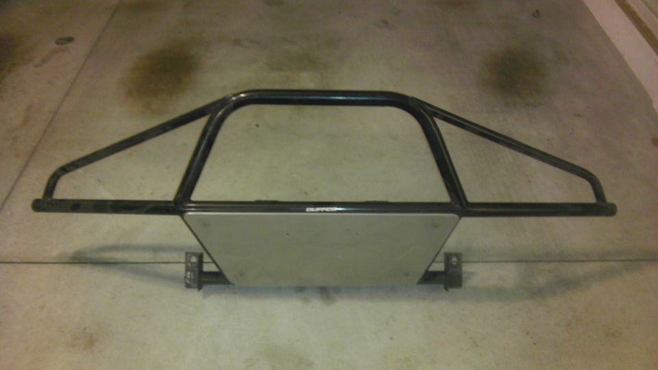 Off-road bumper with a metal skid plate and black tubing. Text on skid plate reads 'SUPERMOTORS'