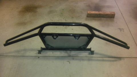 1983 Ferrari Enzo - A black roll cage is displayed on a concrete surface, with a wooden block in the background.