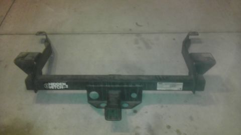 1983 Ferrari Enzo - A trailer hitch receiver with a visible 'Hidden Hitch' logo is shown against a concrete background.