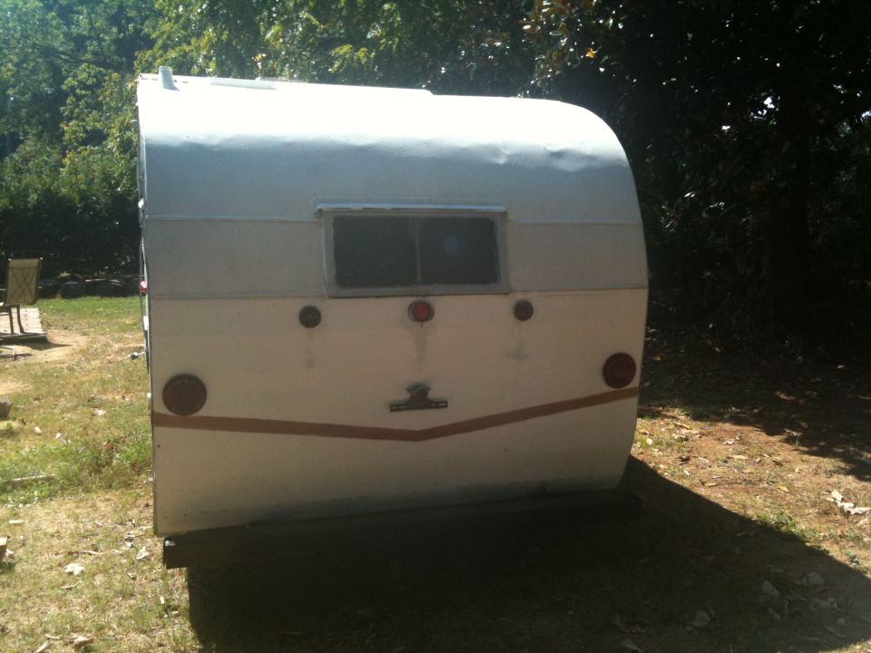 White trailer rear view with two round taillights and a V-shaped trim