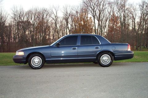 1998 Ford Crown Victoria - Side view of a blue 1998 Ford Crown Victoria sedan parked on a roadside.