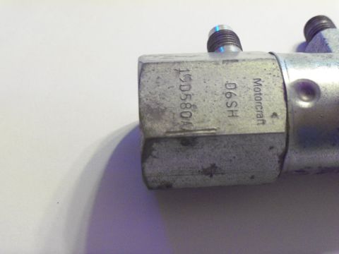 1979 Ford Ranchero - Macro shot of a zinc-plated Motorcraft brake hydraulic block stamped "Motorcraft", "D6SH" and part number 19D580, photographed against a pl…