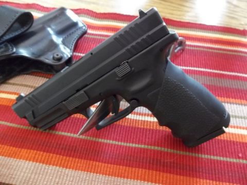 1995 Ford Bronco - A black semi-automatic pistol rests on a striped placemat next to its holster.
