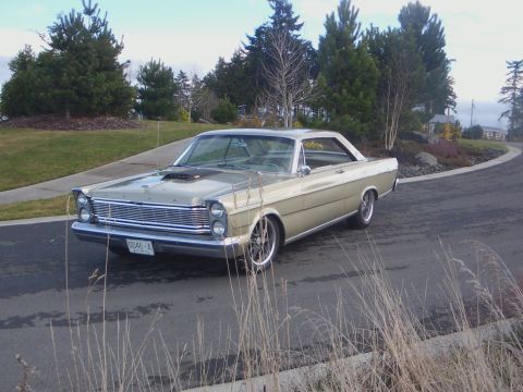 1965 Ford Galaxie - A classic 1965 Ford Custom 500 coupe is seen from the front-three-quarter view on a paved road.